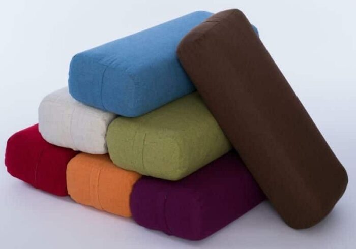 Multiple yoga bolster cushions stacked like a pyramid