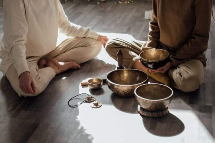 Two persons getting ready for singing bowl meditation