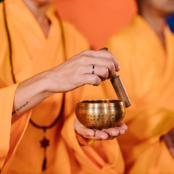 a Buddhist monk playing a Tibetan singing bowl is part of the history of Tibetan singing bowl