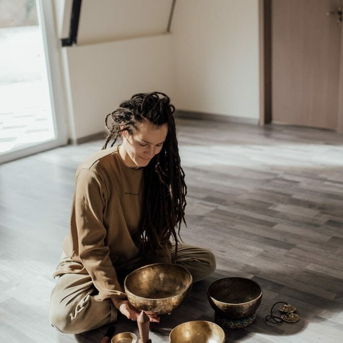 Sitting woman setting up four singing bowls 