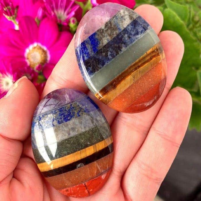 Two multi-colored worry stones on an open palm
