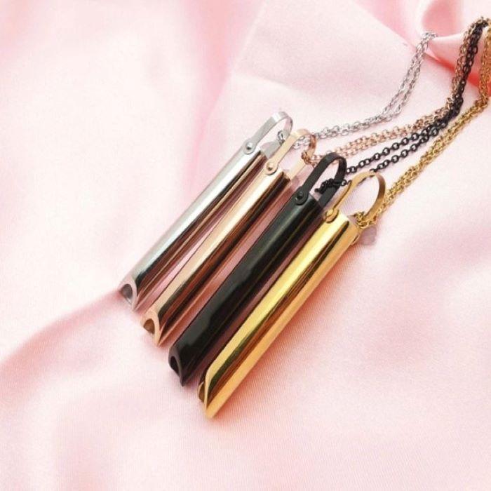 Four anxiety and meditation whistles and chains with varied colors on a pink cloth