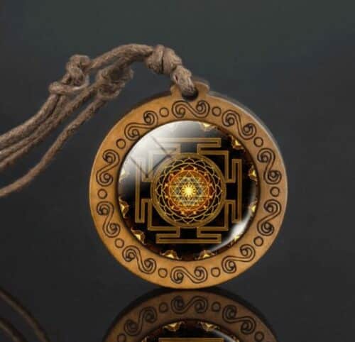 an image of Sri Yantra Mandala Wood Meditation Necklace on a dark backdrop with reflection