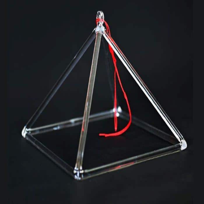 A crystal singing pyramid with a red string with a black background