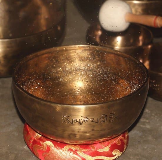 Water-filled large singing bowl being rung