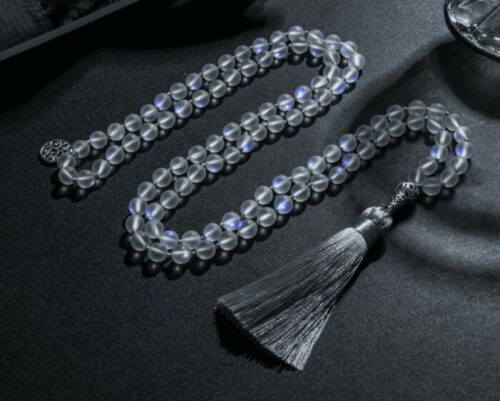 a 108 Austrian Crystal Beaded Meditation Necklace laying in zigzag on a black flat surface