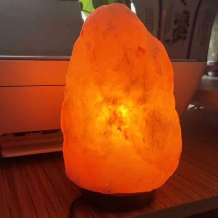 A mineral salt meditation lamp glowing with a soft orange light