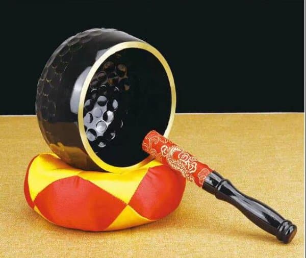 Black singing bowl place sideways with red-tipped mallet