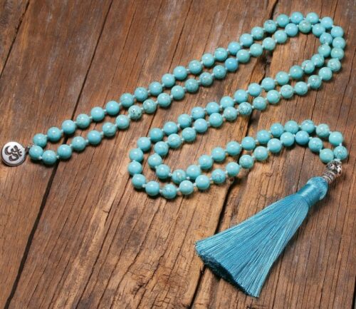 an image of Turquoise Zen Spiritual Meditation Necklace laying flat in a wood surface