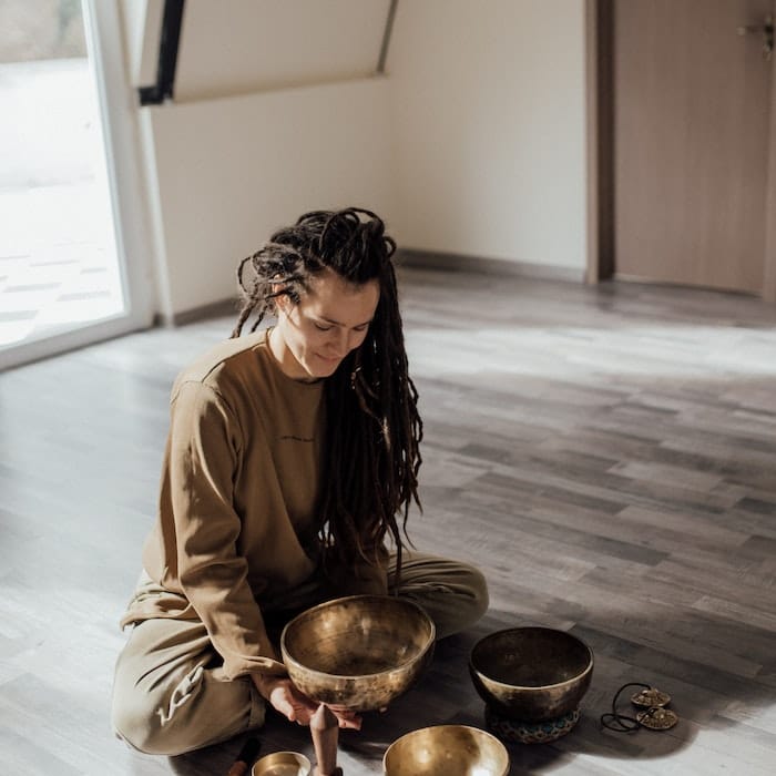 Sitting woman setting up four singing bowls 